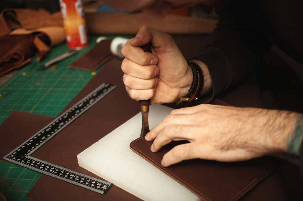 tanner makes leather product, purse. With your own hands, DIY instruction, indoor, closeup